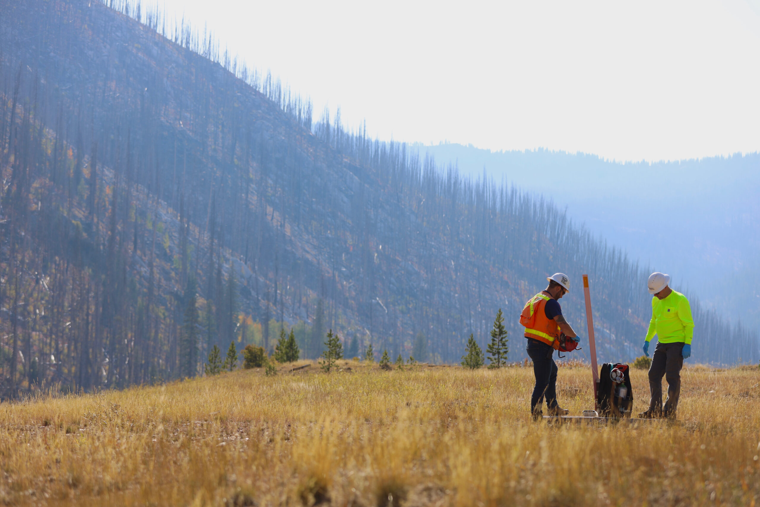 2 field workers operating on a mountain