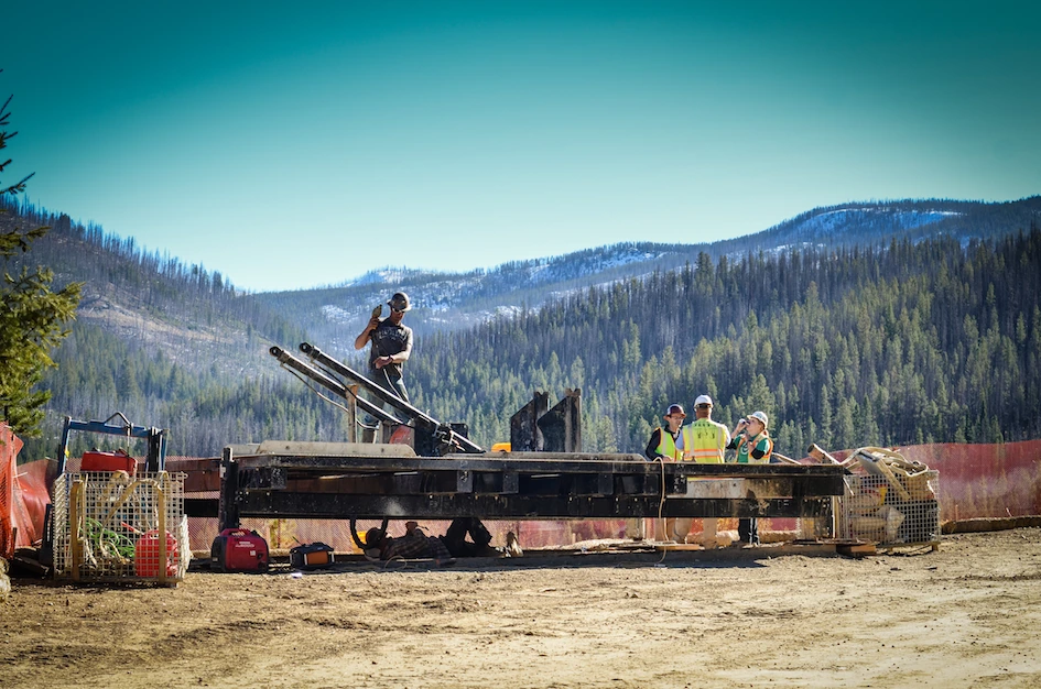Field workers maintaining machinery