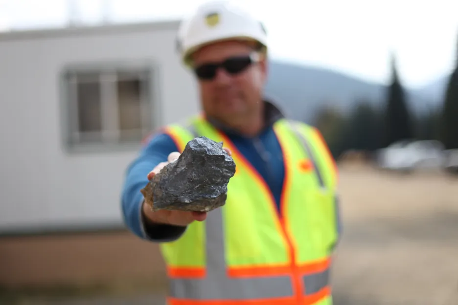 A Perpetua worker holding a piece of antimony ore