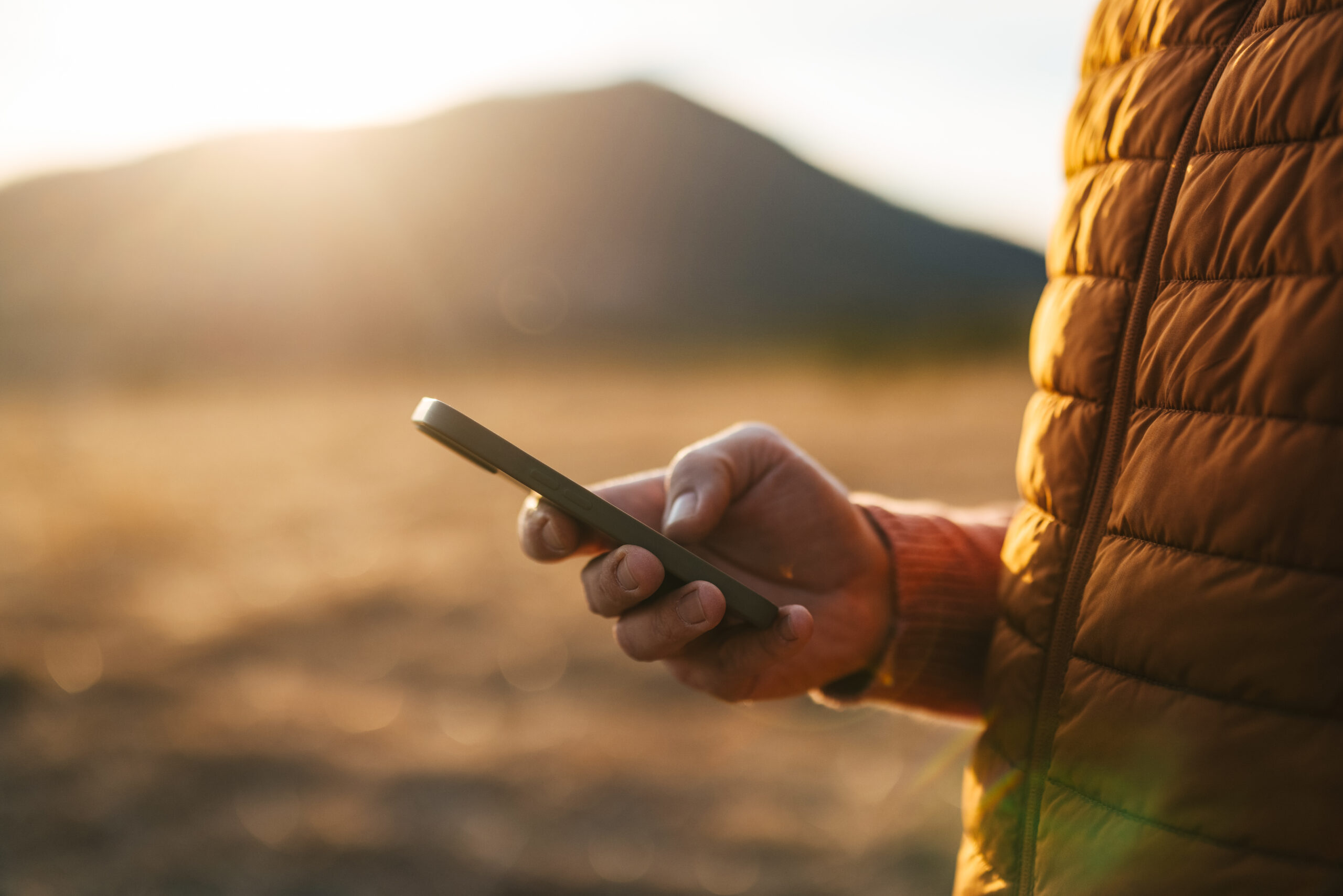 Close-up of a hand holding a smartphone outdoors