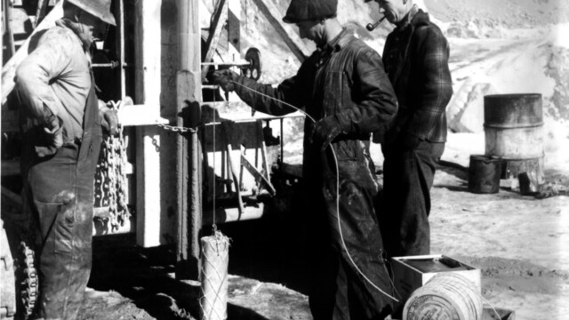 1946, Churn drill and blast crew loading ammonium nitrate bags into blast hole, c. 1946. Bill Newell (L), Ed Adams (R) Idaho State Historical Society Svg+xml,%3Csvg%20xmlns%3D%22http%3A%2F%2Fwww.w3.org%2F2000%2Fsvg%22%20width%3D%2